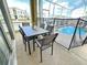 Enclosed patio features a dining table and chairs, offering serene views of the pool and backyard at 949 Leader St, Davenport, FL 33896