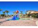Community water park with colorful splash pad, palm trees, and beautiful clubhouse in the background at 949 Leader St, Davenport, FL 33896