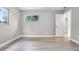 The bedroom has wood-look flooring, neutral walls, two windows and a door leading to another room at 1859 Matterhorn Dr, Orlando, FL 32818