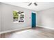 Bright bedroom showcasing wood-look flooring, a window and a stylish blue door at 1859 Matterhorn Dr, Orlando, FL 32818