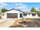 Charming single-story home featuring a two-car garage, a blue front door and a well-maintained front yard at 1859 Matterhorn Dr, Orlando, FL 32818
