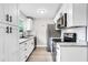 Modern kitchen featuring sleek white cabinets, granite countertops, and stainless steel appliances at 1859 Matterhorn Dr, Orlando, FL 32818