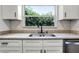 Updated kitchen sink with modern faucet, stone countertop, and view of trees from the window at 1859 Matterhorn Dr, Orlando, FL 32818