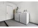 Laundry room features a white washer and dryer set, water heater and painted concrete flooring at 1859 Matterhorn Dr, Orlando, FL 32818