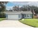 Charming single-story home featuring a well-manicured lawn, attached two-car garage, and inviting entrance at 1077 Dees Dr, Oviedo, FL 32765