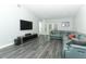 Open living room with modern flooring, a comfortable sofa, and a wall-mounted TV at 1077 Dees Dr, Oviedo, FL 32765