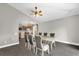 Dining room with hardwood floors, neutral paint, a modern chandelier, and a view into the adjacent kitchen at 10930 Buckwater Ct, Orlando, FL 32817