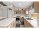 Well-lit kitchen with a stainless steel appliances, light wood cabinets, tile backsplash, and a view into the living space at 10930 Buckwater Ct, Orlando, FL 32817