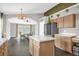 Bright kitchen with light wood cabinets, a stainless steel refrigerator, and a view into the adjacent dining area at 10930 Buckwater Ct, Orlando, FL 32817