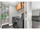 Laundry room equipped with modern washer and dryer, shelving, and convenient access to living area at 10930 Buckwater Ct, Orlando, FL 32817