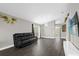 Spacious living room with hardwood floors, neutral paint, a large window, and a comfortable black sofa at 10930 Buckwater Ct, Orlando, FL 32817