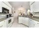 Bright kitchen features white cabinets, stainless steel appliances, and stone countertops at 11512 Clair Pl, Clermont, FL 34711