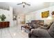 Bright living room featuring tile flooring, a ceiling fan, and comfortable seating at 11512 Clair Pl, Clermont, FL 34711