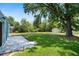 Expansive backyard with a concrete patio, lush green grass, mature trees, and a wooden shed at 11520 Churchill St, Orlando, FL 32817