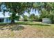 Lush backyard with mature trees, a storage shed, and ample space for outdoor activities at 11520 Churchill St, Orlando, FL 32817