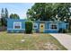 Inviting single-story home with a blue exterior, bright yellow door, and well-maintained front yard at 11520 Churchill St, Orlando, FL 32817