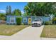 Charming home with a bright yellow front door, a long driveway, and well-maintained landscaping at 11520 Churchill St, Orlando, FL 32817