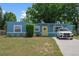 Beautiful blue home with a yellow door and a well-manicured lawn, showcasing its charm and curb appeal at 11520 Churchill St, Orlando, FL 32817