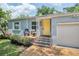 Close up front view of a cute home with a yellow door and chairs on the brick porch at 1225 Golfview St, Orlando, FL 32804
