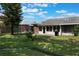 Expansive backyard features mature trees and patio, offering a private and serene outdoor space at 1230 Americana Pl, Orlando, FL 32807