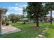 Expansive backyard with lush green grass, mature trees, and a brick paver patio with grill at 1230 Americana Pl, Orlando, FL 32807