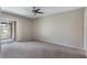 Bedroom with neutral carpet, ceiling fan, and sliding glass door to porch at 1230 Americana Pl, Orlando, FL 32807