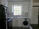 Updated kitchen featuring white cabinets, black appliances, and a convenient washer-dryer unit at 1250 S Denning Dr # 108, Winter Park, FL 32789