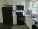 Contemporary kitchen with white cabinets, black appliances, and stylish backsplash at 1250 S Denning Dr # 108, Winter Park, FL 32789