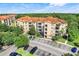 An aerial view of a multi-story residential building with a terracotta tile roof and well-manicured green space at 1375 Tuscana Ln # 1102, Davenport, FL 33896