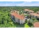An aerial view of terracotta-roofed condos surrounded by mature trees and manicured green lawns at 1375 Tuscana Ln # 1102, Davenport, FL 33896
