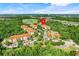 Overhead view of a community nestled among lush green trees, featuring a golf course, pool and multiple condo buildings at 1375 Tuscana Ln # 1102, Davenport, FL 33896