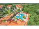Birds-eye view of community pool area, manicured lawns, lush tropical foliage, and residential buildings with terracotta roofs at 1375 Tuscana Ln # 1102, Davenport, FL 33896