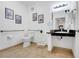 Bright bathroom with neutral tile, framed art, black countertop, white cabinets and commode, towel rack and accessible grab bars at 1375 Tuscana Ln # 1102, Davenport, FL 33896