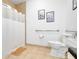 Bathroom with neutral tile, accessible grab bar, framed art, shower with a white curtain, and commode with paper band at 1375 Tuscana Ln # 1102, Davenport, FL 33896