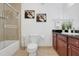 Bathroom with shower-tub combination and a granite countertop vanity and brown cabinets at 1375 Tuscana Ln # 1102, Davenport, FL 33896