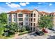 Lovely condo building with balconies, stone accents, green landscaping, and parking spaces at 1375 Tuscana Ln # 1102, Davenport, FL 33896