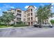 A multi-story building featuring stone accents, a parking lot and a well-maintained landscape at 1375 Tuscana Ln # 1102, Davenport, FL 33896