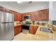 Well-equipped kitchen with stainless steel appliances, granite countertops, and wooden cabinetry at 1375 Tuscana Ln # 1102, Davenport, FL 33896