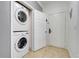 Hallway view of stacked white washer and dryer and an open door leading to the front door at 1375 Tuscana Ln # 1102, Davenport, FL 33896