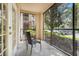 Screened in porch with table and chairs with view of trees and parked cars at 1375 Tuscana Ln # 1102, Davenport, FL 33896