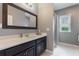 Bathroom featuring a large framed mirror, white countertops, dark cabinets, and natural light at 14357 United Colonies Dr, Winter Garden, FL 34787