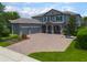 Beautiful home boasts a paver driveway, three-car garage, and well-manicured landscaping at 14357 United Colonies Dr, Winter Garden, FL 34787