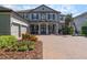Charming two-story home with a paver driveway, three-car garage, and professionally landscaped yard at 14357 United Colonies Dr, Winter Garden, FL 34787