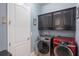Laundry room featuring a front-loading washer and dryer plus overhead cabinets at 14357 United Colonies Dr, Winter Garden, FL 34787