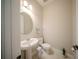 Powder room with a pedestal sink, round mirror and tiled floor at 16055 Silver Brook Way, Winter Garden, FL 34787