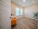 Bright bedroom featuring wood floors, two windows, and a cozy yellow chair at 16055 Silver Brook Way, Winter Garden, FL 34787