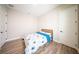 A well-lit bedroom featuring a bed with blue accents and wood flooring at 16055 Silver Brook Way, Winter Garden, FL 34787