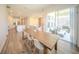 Bright, open-concept dining area with wood floors, leads to a modern kitchen and outdoor patio at 16055 Silver Brook Way, Winter Garden, FL 34787