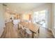 Bright, open-concept dining area with wood floors, leads to a modern kitchen and outdoor patio at 16055 Silver Brook Way, Winter Garden, FL 34787