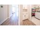 Hallway with wood-look flooring leading to a laundry area with washer and plenty of storage at 16055 Silver Brook Way, Winter Garden, FL 34787